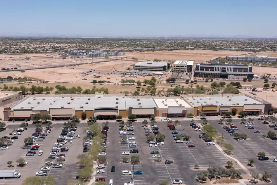Aerial view of sprawling commercial development with parts still under construction and parking lot in Goodyear, Arizona